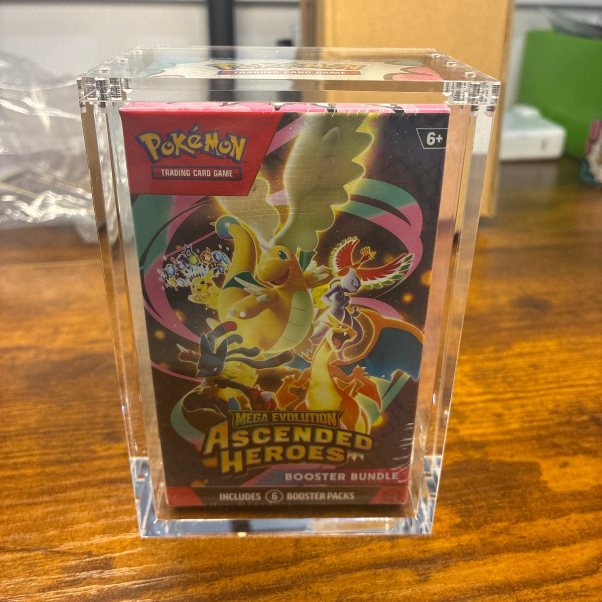 Clear acrylic Booster Bundle protector fitted around a sealed Pokemon Booster Bundle box